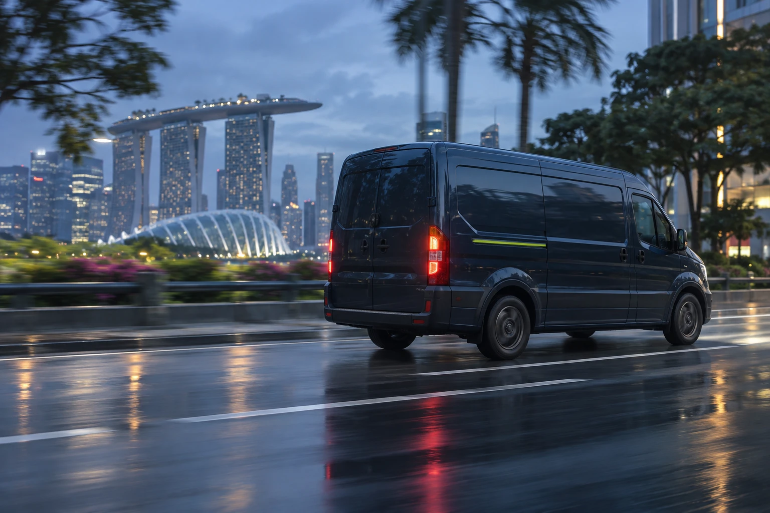 A dark navy Morrow van with a lime stripe drives along a wet road at dusk, with the Marina Bay skyline behind.